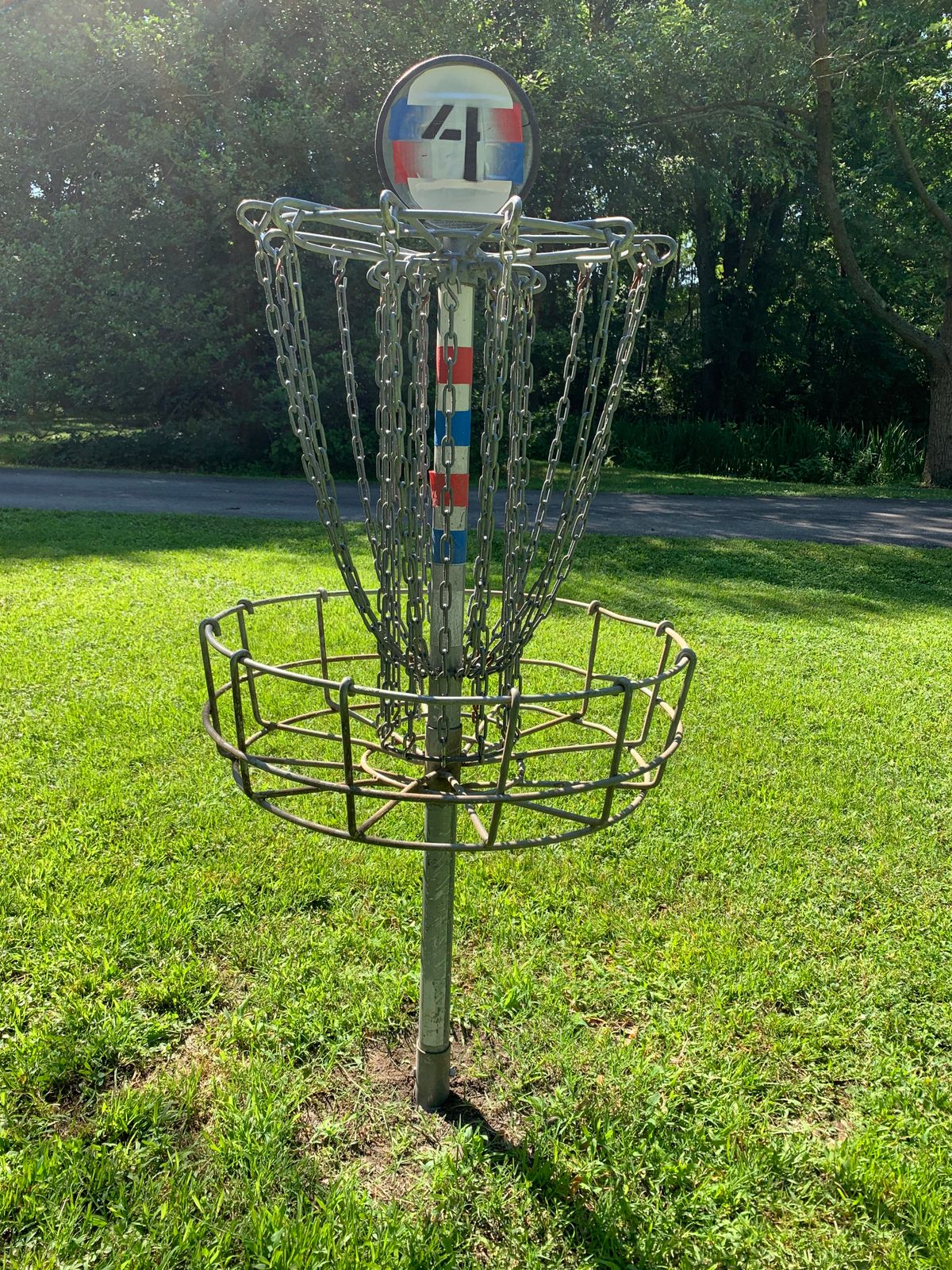 Hole 4 blue and red basket sits about 20’ from OB pavement and pond further behind!