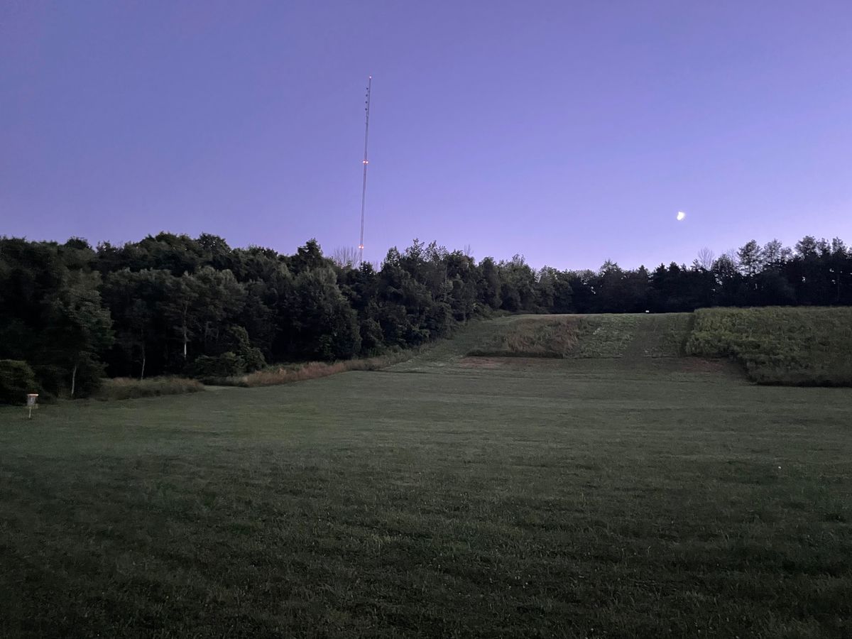 Looking up the hill behind 18’s basket with a crescent moon.