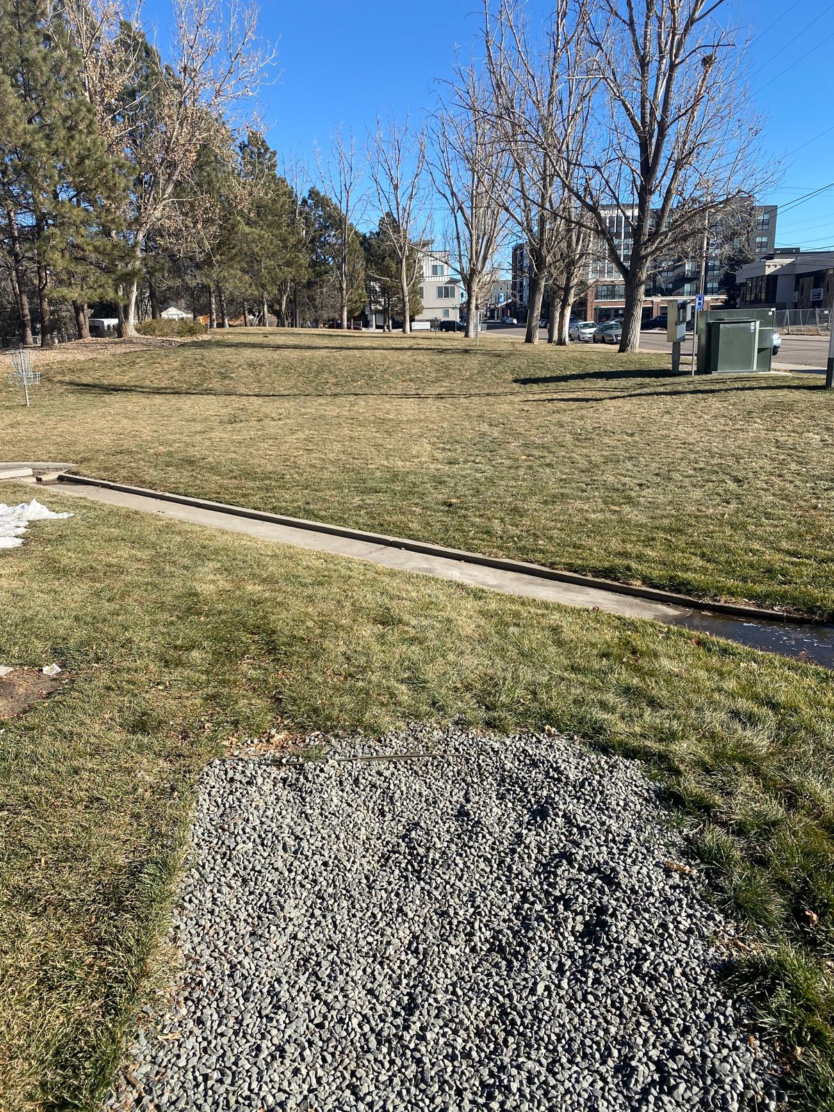 Hole 1 tee. Hole 1 basket is off to the right. The basket at the left of the photo is for hole 5.