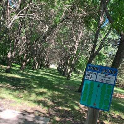View of hole 5 tee pad & sign. Narrow tunnel shot. Fun throw.