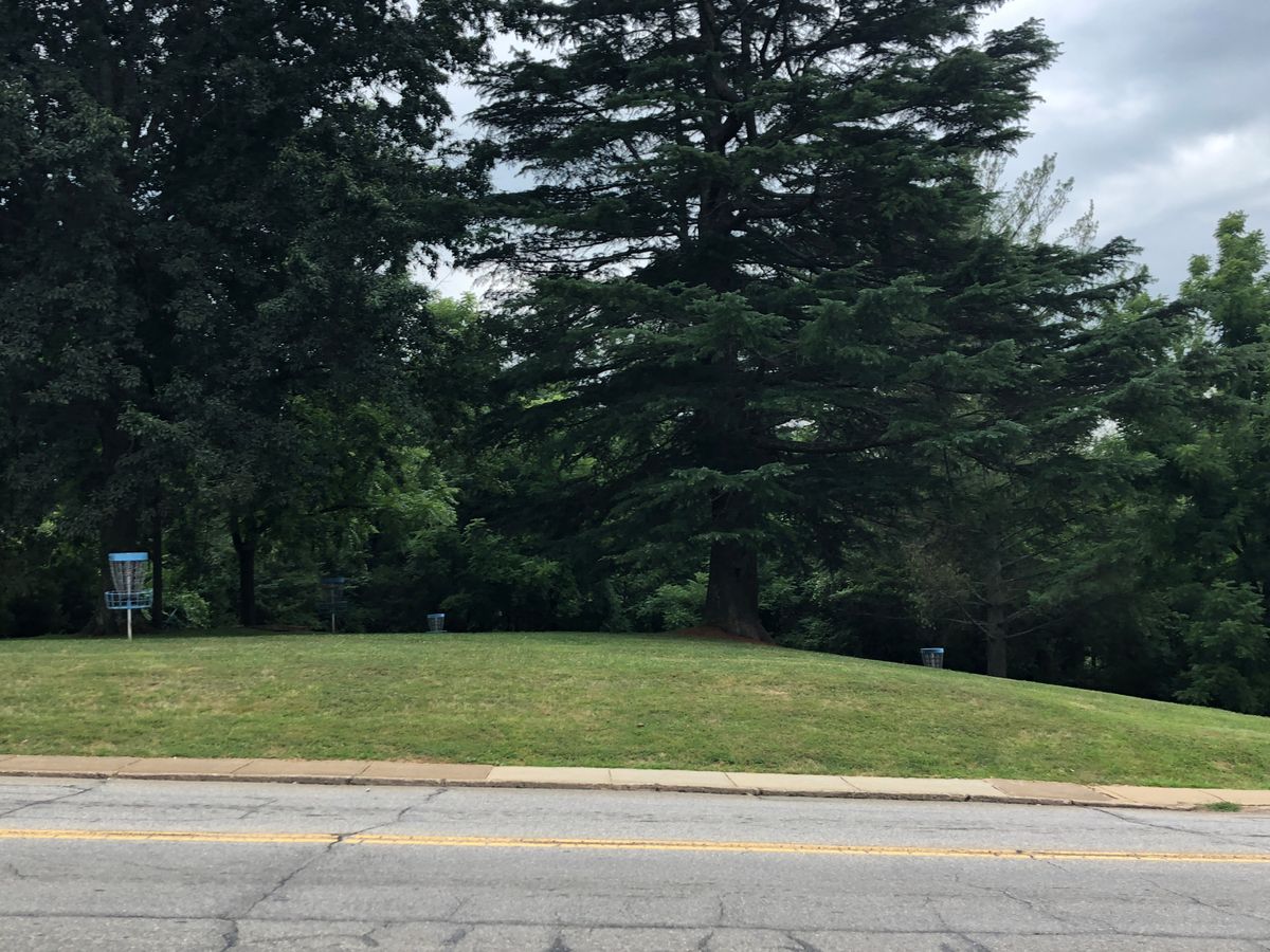 From across the street, six Prodigy baskets with 18 cement tee markers, mostly circle 1 and 2