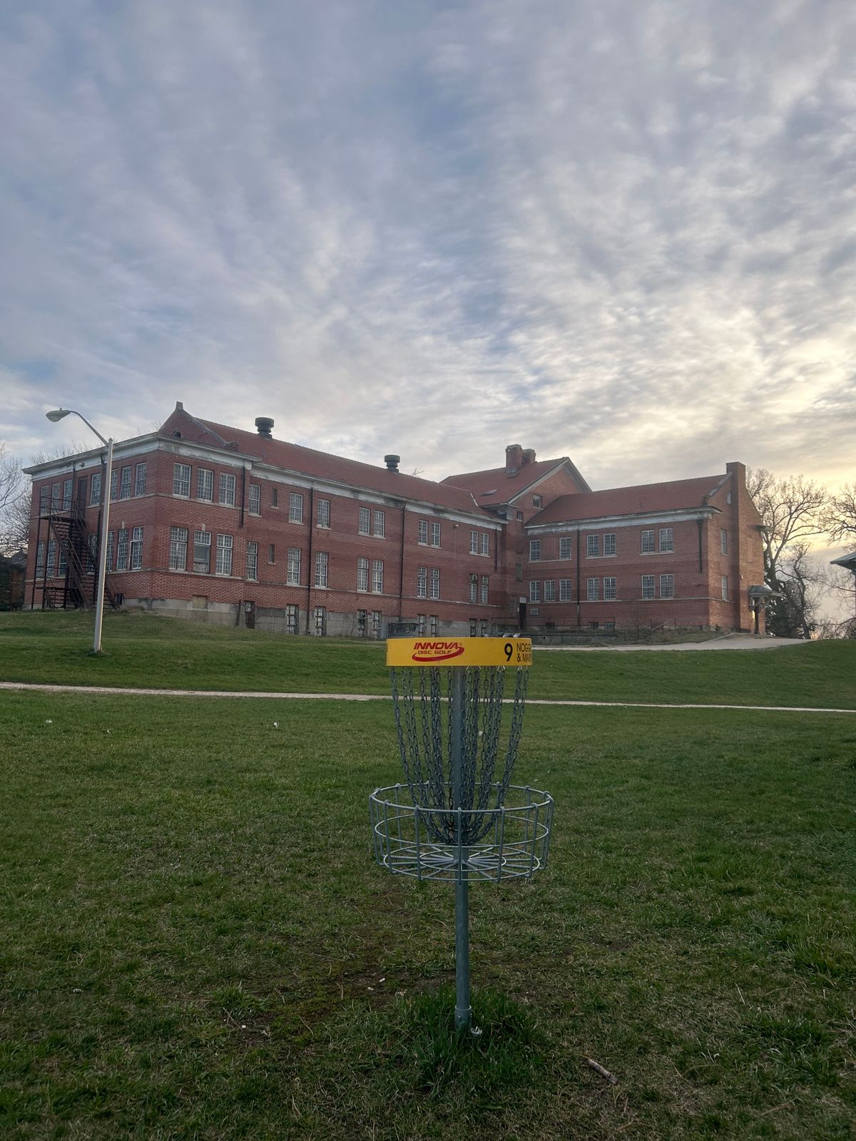 Hole 9 basket overlooking an old institution building