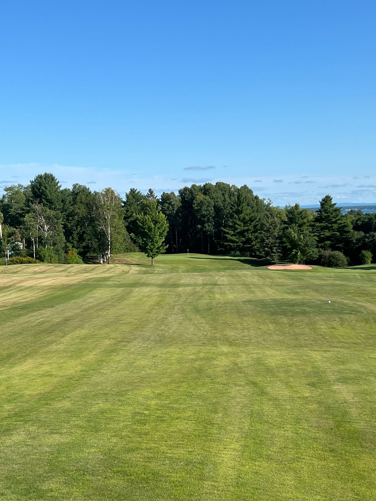 Hole 1 teepad, basket to the left, teepad blue gold tee within view of Lake Superior