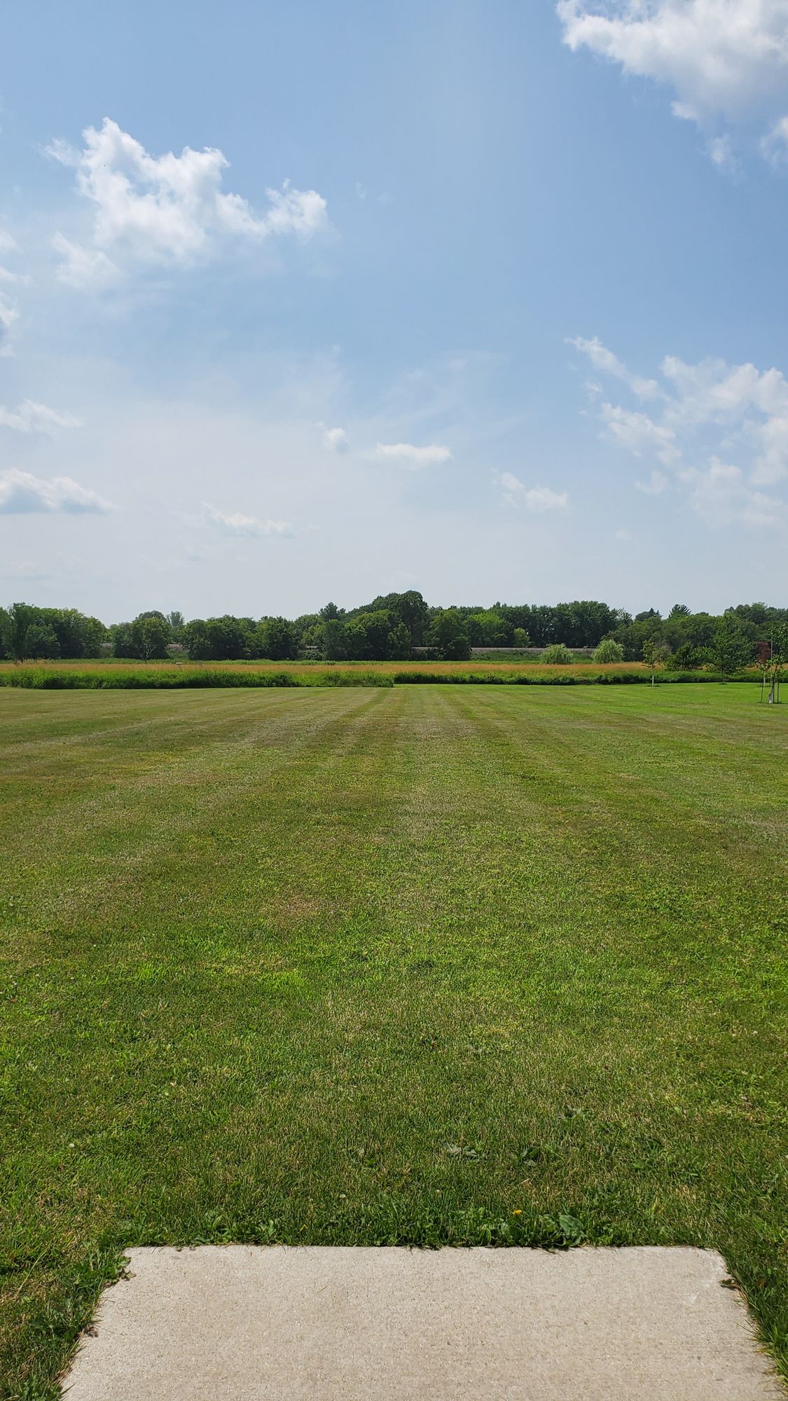 Hole 7 tee. Hole is over a open field and over a water hazard.