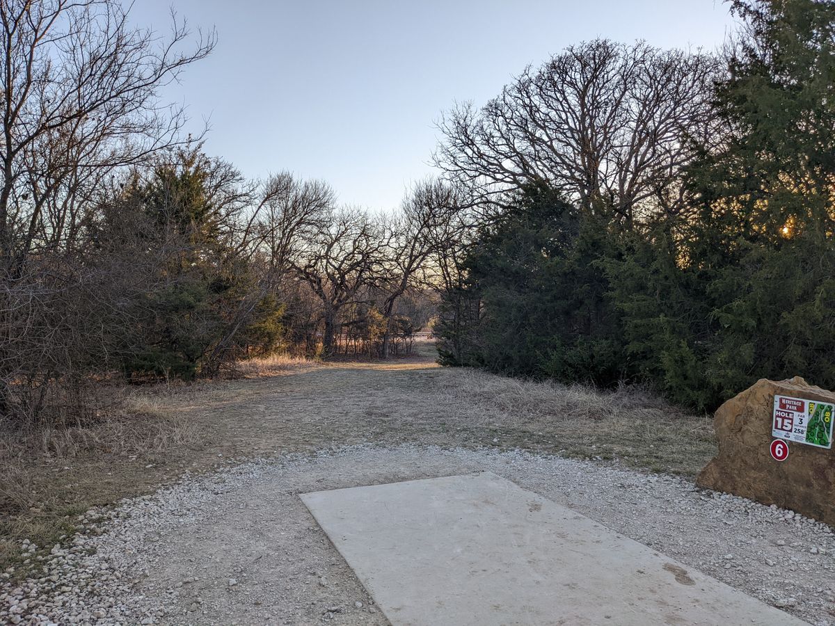 Hole 15 - dogleg right, basket across the ditch. Sidewalk & beyond on right is OB. Road & beyond OB on left.