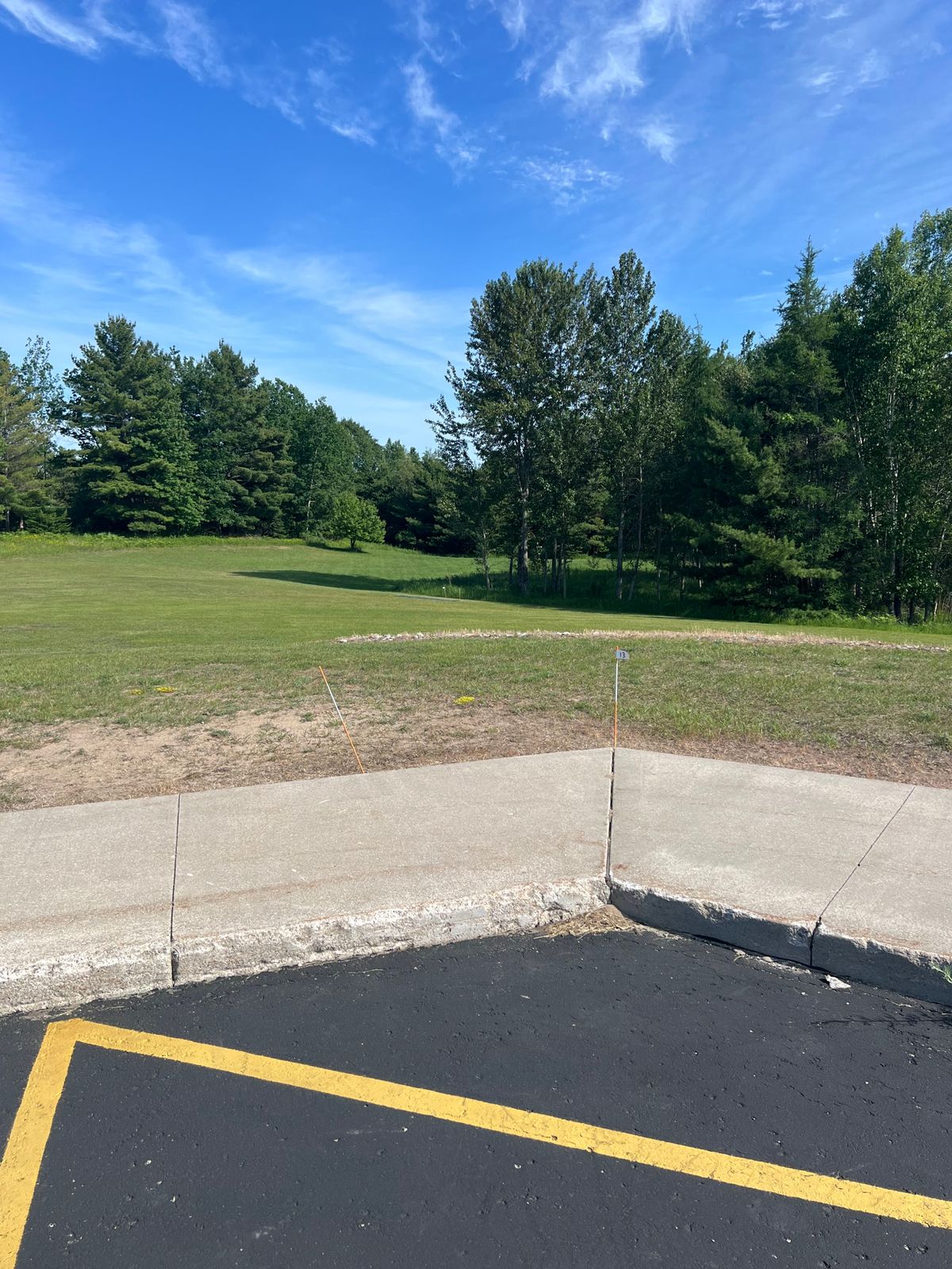 Tee pad 13 - throw from the pavement or sidewalk (your choice) - basket is ahead and to the right 