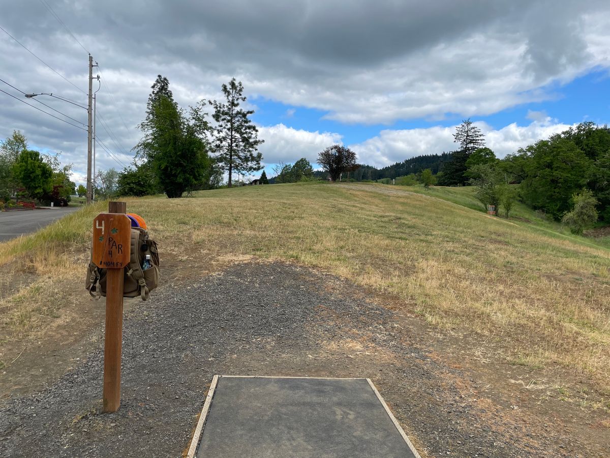 Hole 4 tee pad looking out towards the basket. Reach the top of this hill and pitch up for a birdie.