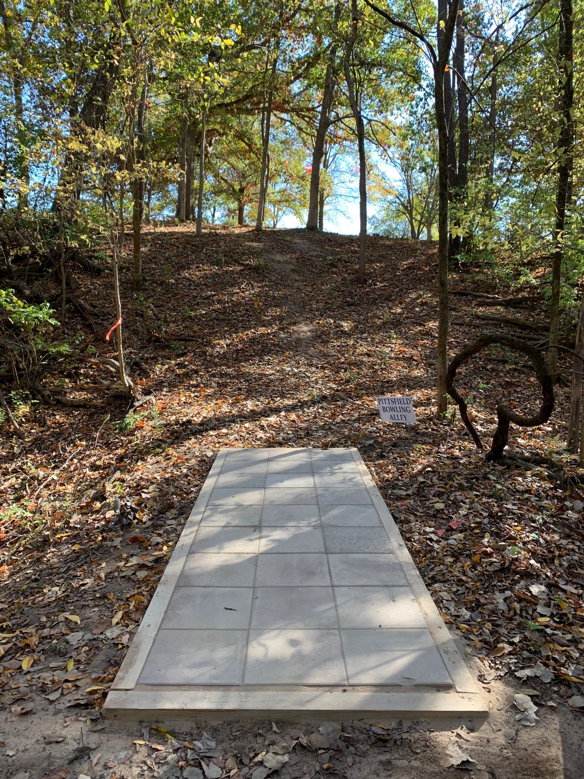 Uphill tee shot. Only tee pad not concrete. Stone pavers. 