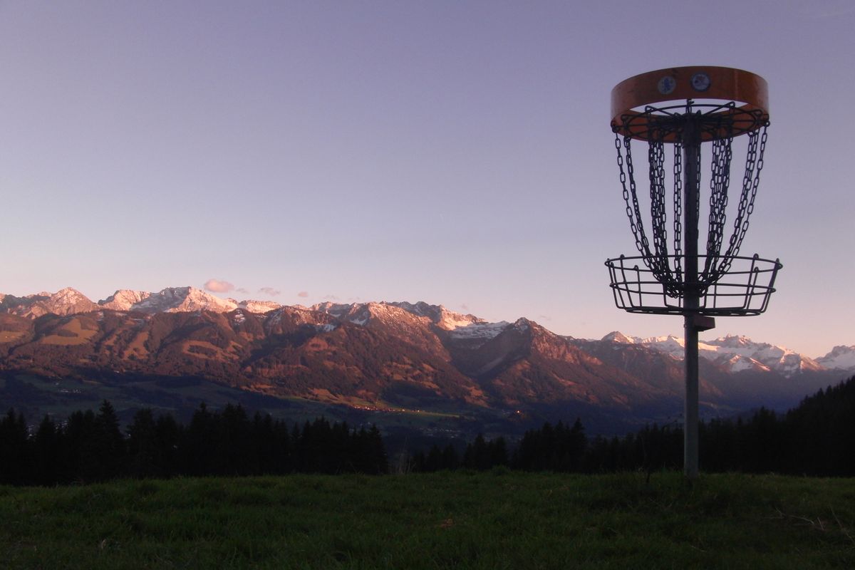 As the sun sets over the Allgauer Alps behind hole 1