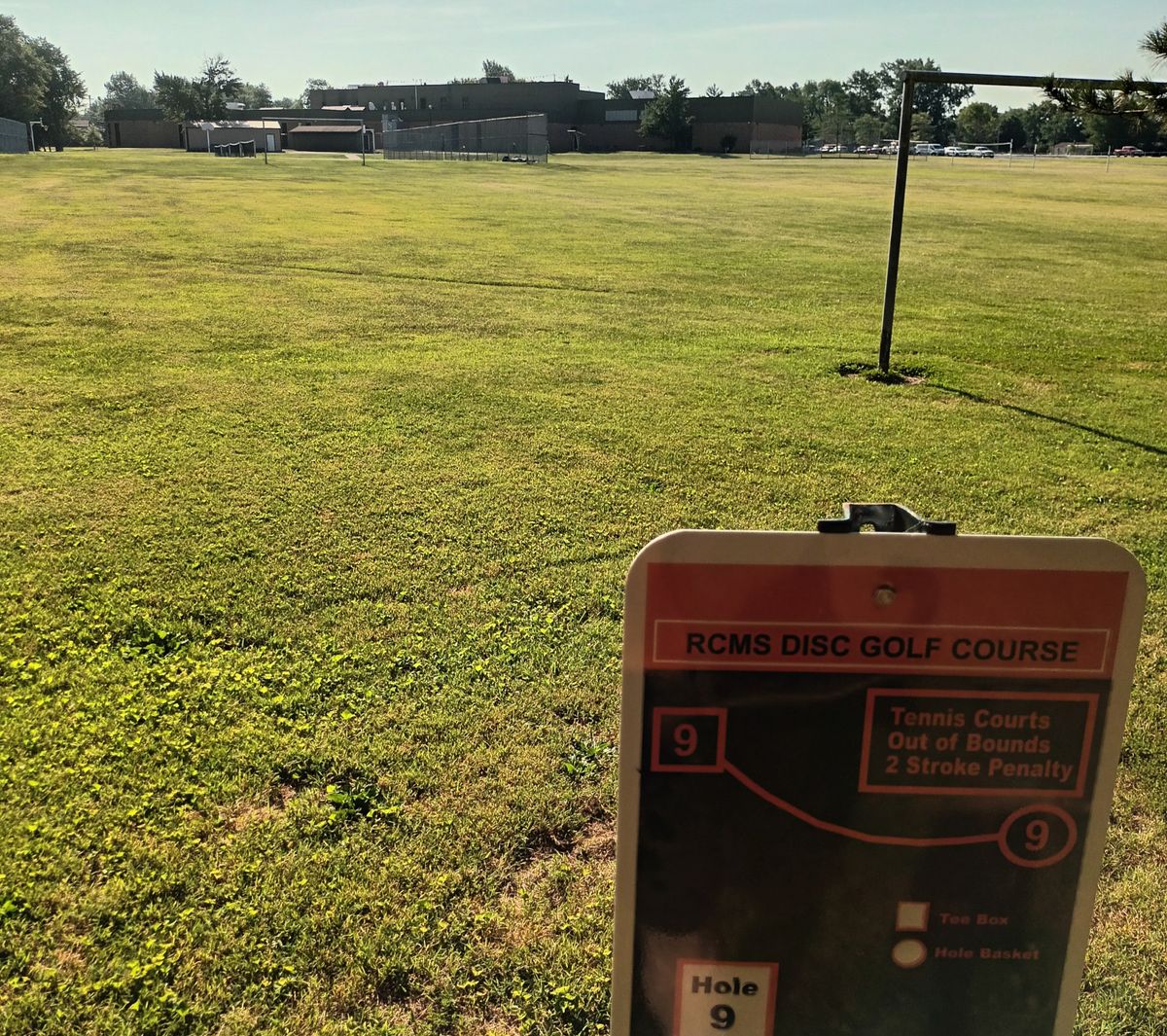 Hole 9. Basket alongside fence on right.  Tennis court OB Hazard