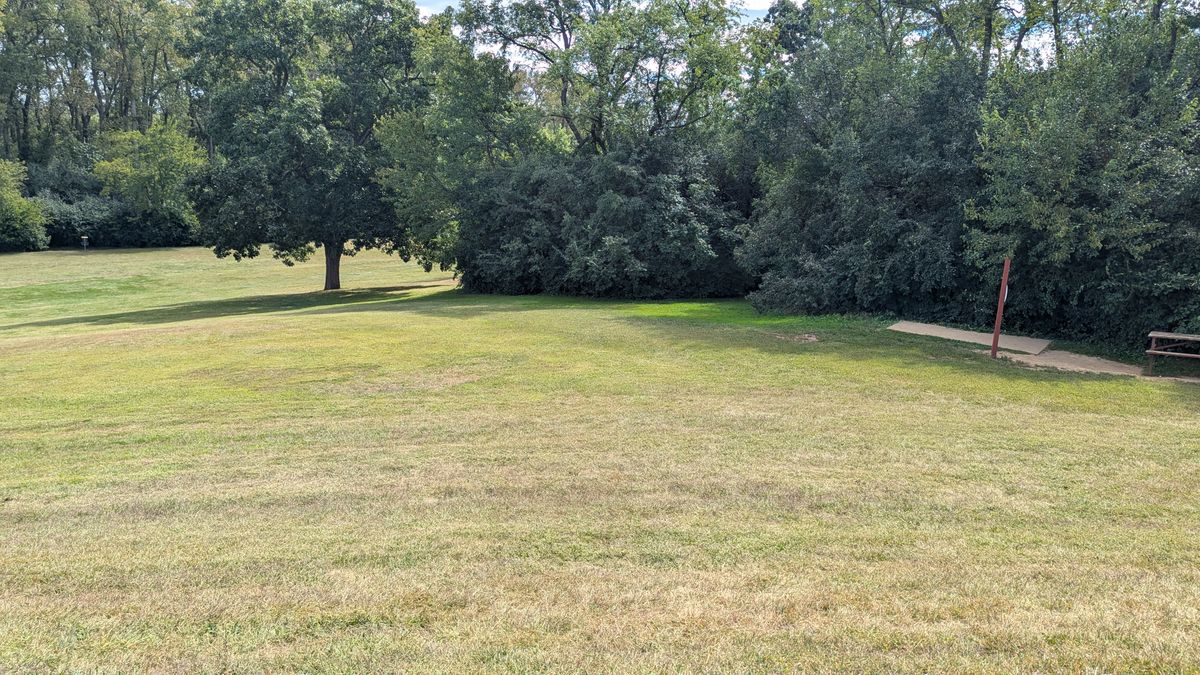 Hole 3 signage and pad on the right and the basket far in the distance on the left