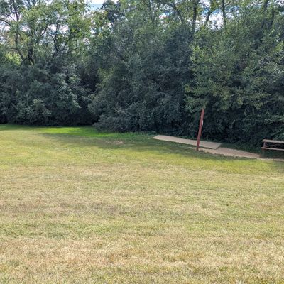 Hole 3 signage and pad on the right and the basket far in the distance on the left