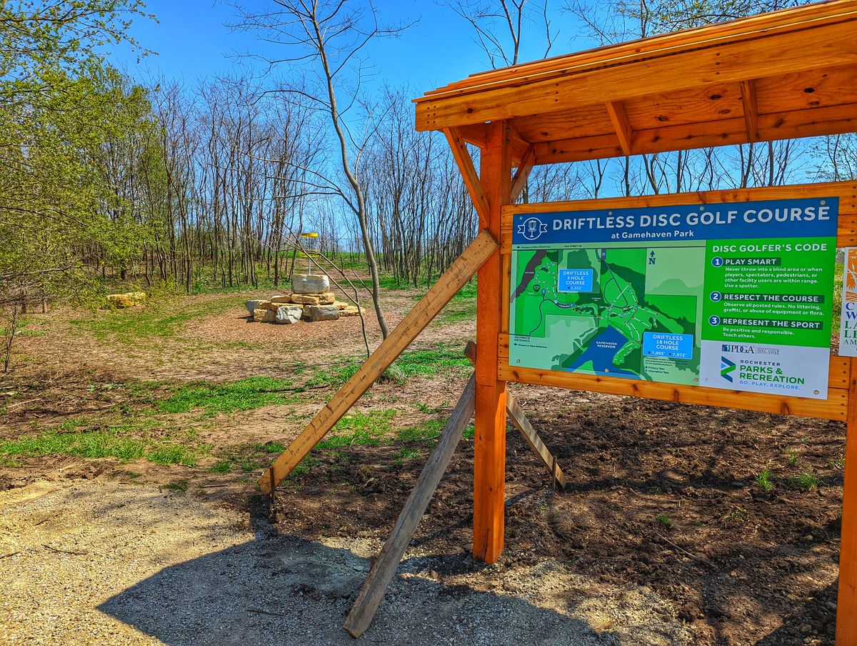 Course sign with hole 18 basket in the background.