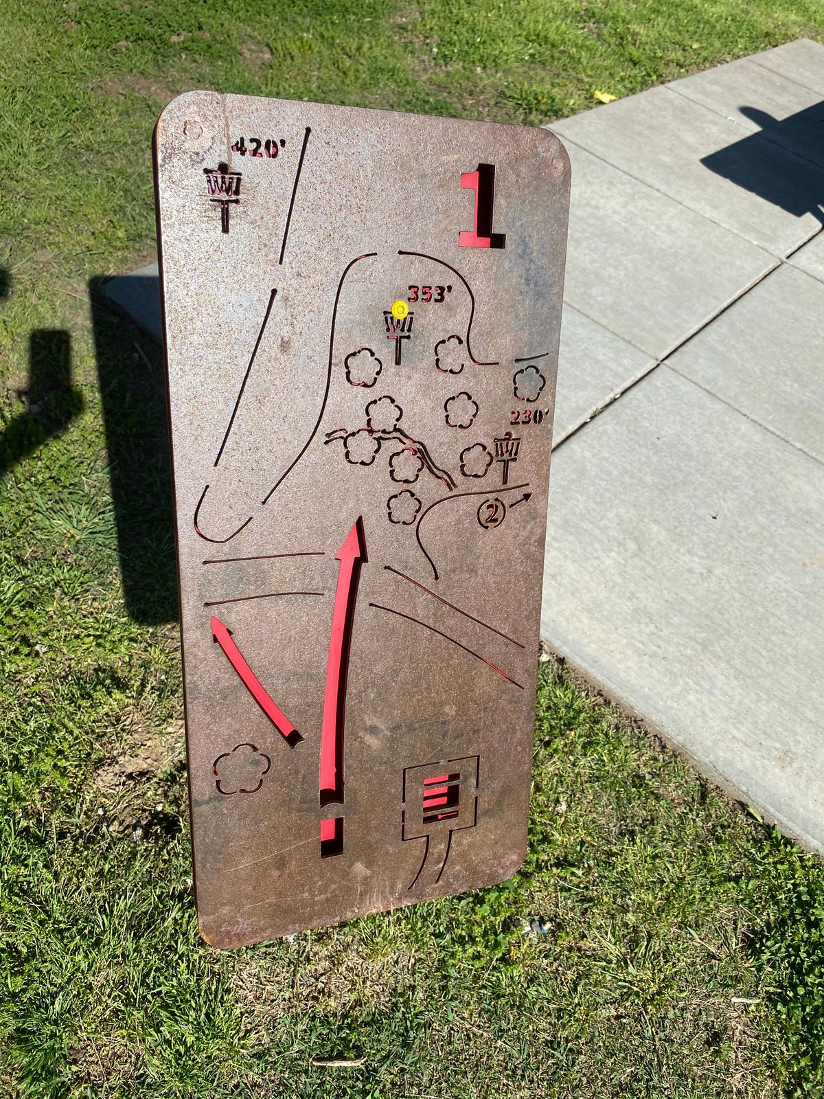 Hole 1 tee sign with yellow and red pin positions and arrow pointing down main fairway and left to long alternate position. 