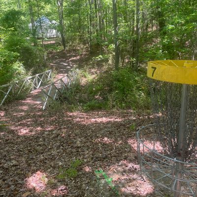 Hole 7 basket, take bridge, go PAST first set of yurts to next set for 8.