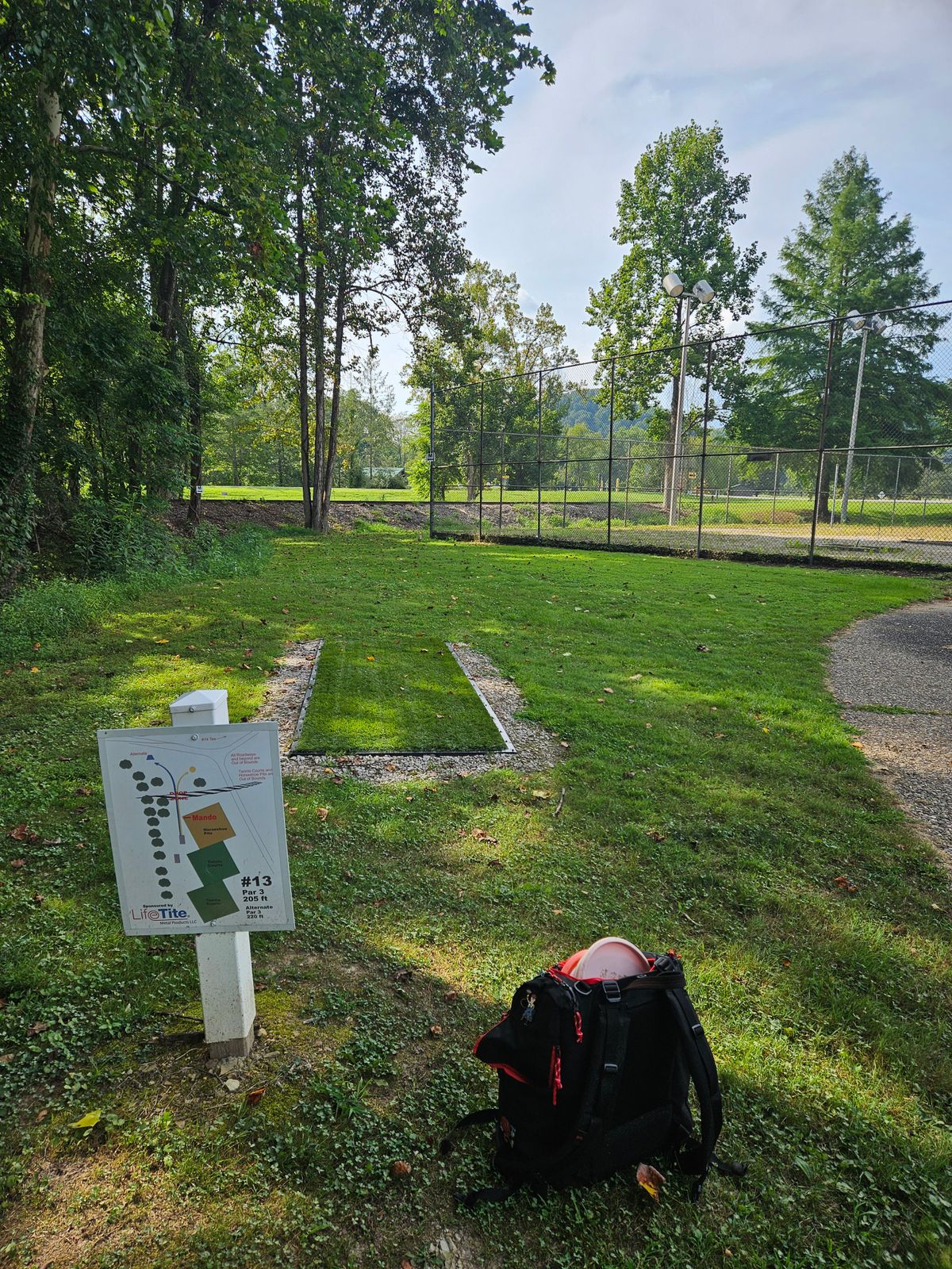 Hole 13 Short Teepad. Short Basket Right, Long Basket Left. Note: Mandatory Left of Fence Corner. OB staked along Left side of fairway.