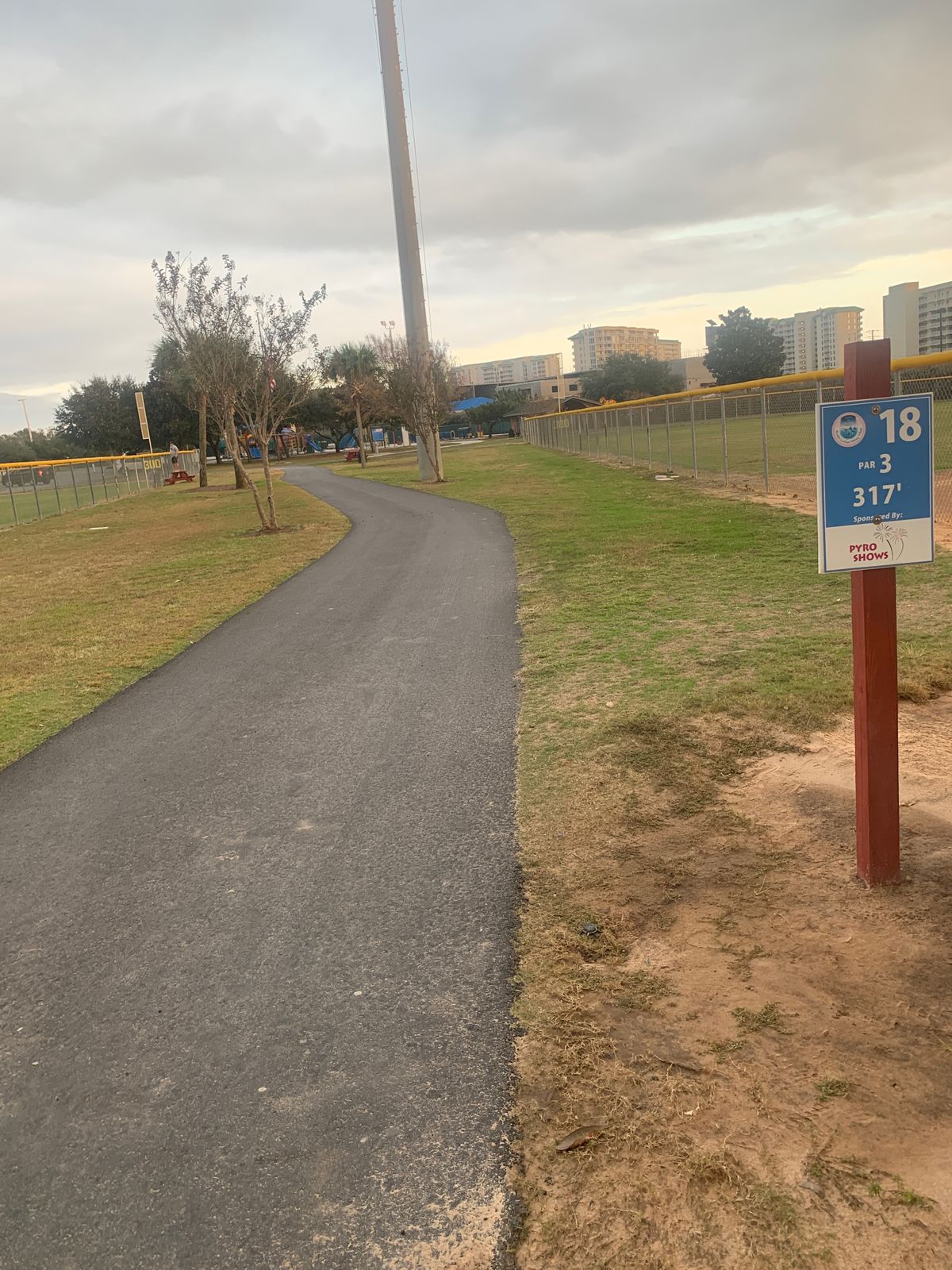 Near the playground, straight ahead just past the flagpole