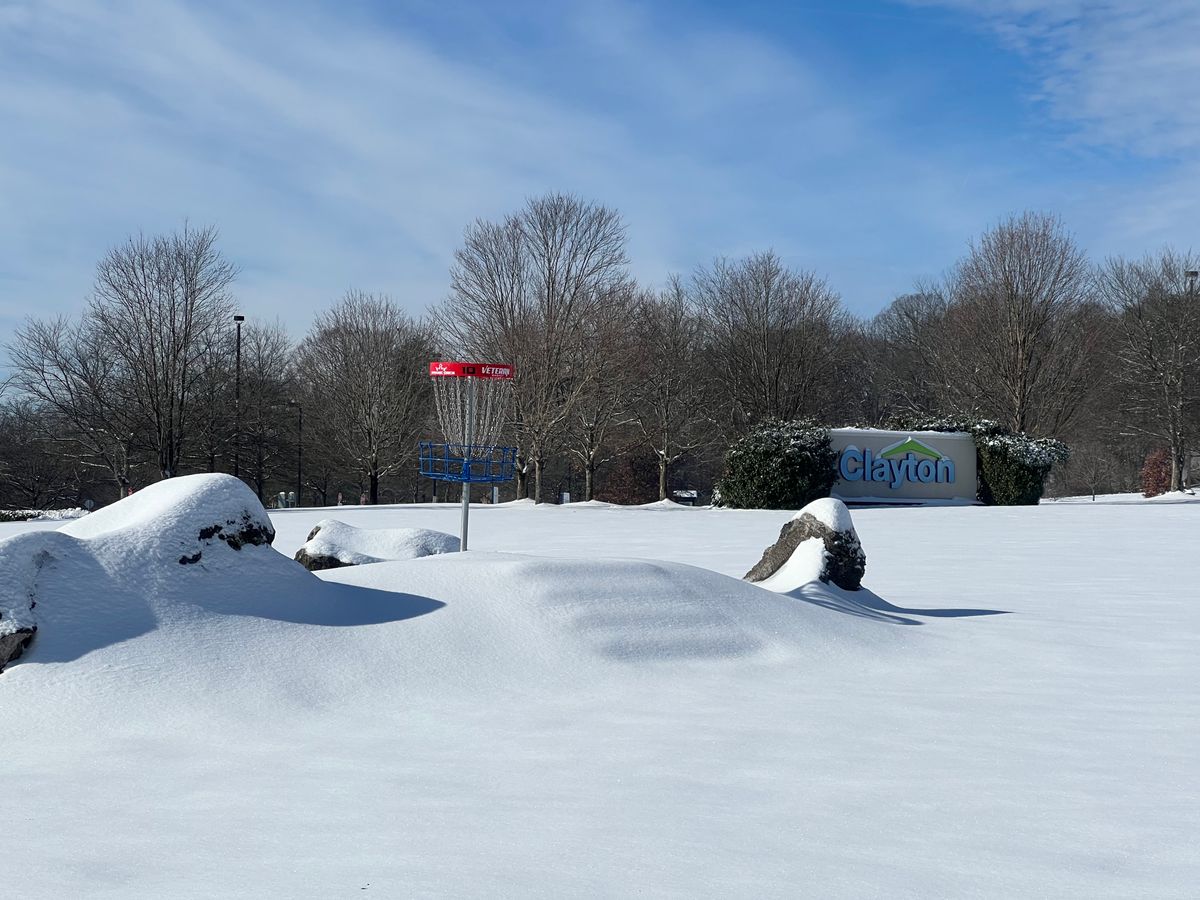 A snowy hole 10’s short basket in front of the Clayton Homes corporate sign