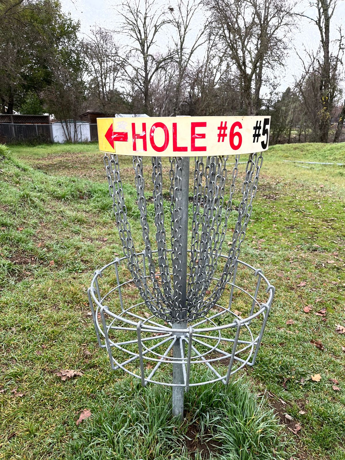 Arrow on basket #5 pointing to next tee.
