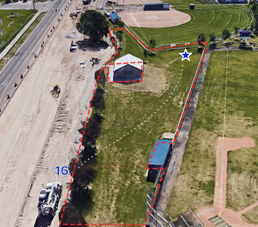 Tee on asphalt pathway underneath tree. There may be spray painted line there. Ob road and baseball