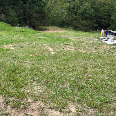 Hole 1. 160 ft slight left behind the big pine. First tee pad is behind the green bus garage.