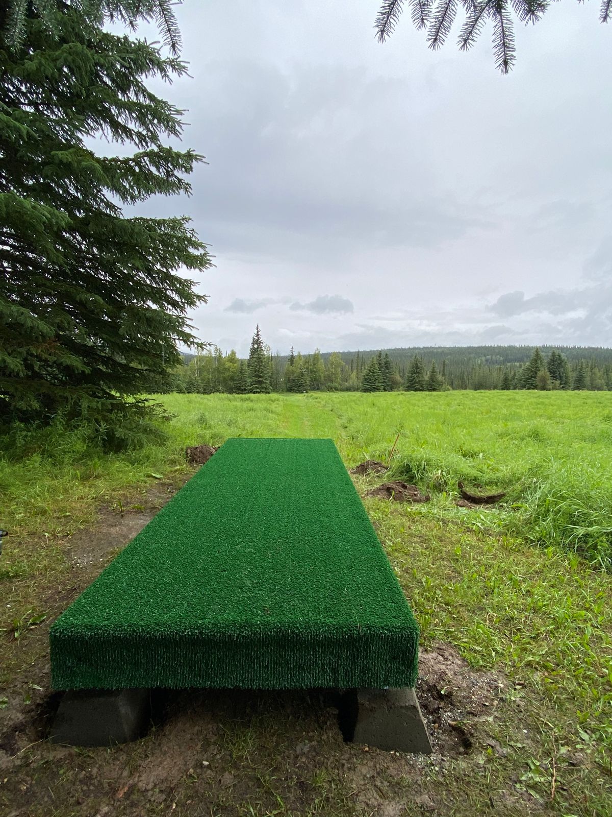 Hole 9 tee pad, basket down at bottom of hill inside trail bordering tree line.