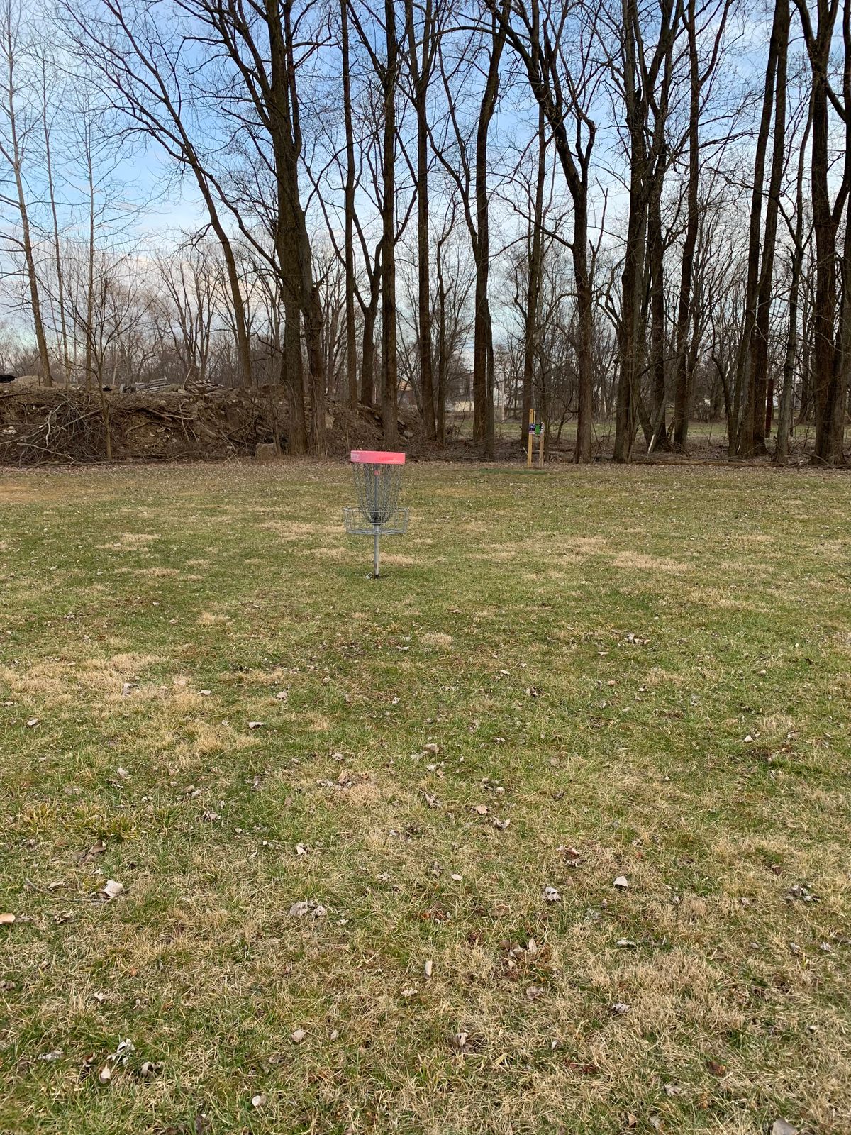 Red practice basket by 2 tee pad.