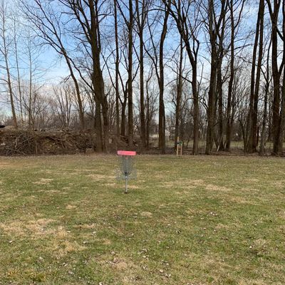 Red practice basket by 2 tee pad.