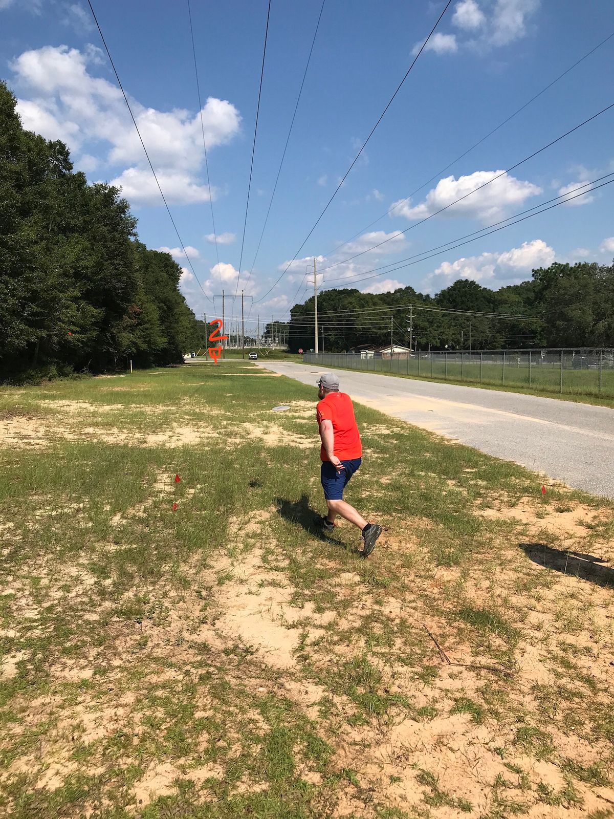 Hole 2: triple island. OB road on right and two dirt roads running horizontally in fairway