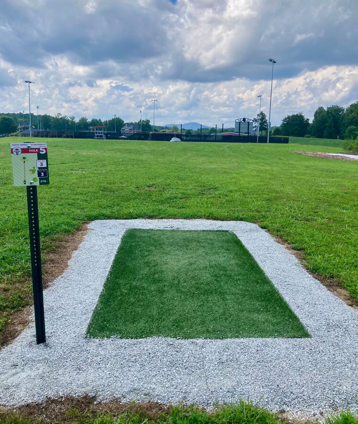 Hole 5 T-Pad with elevated basket in rock and the mountains in the background!