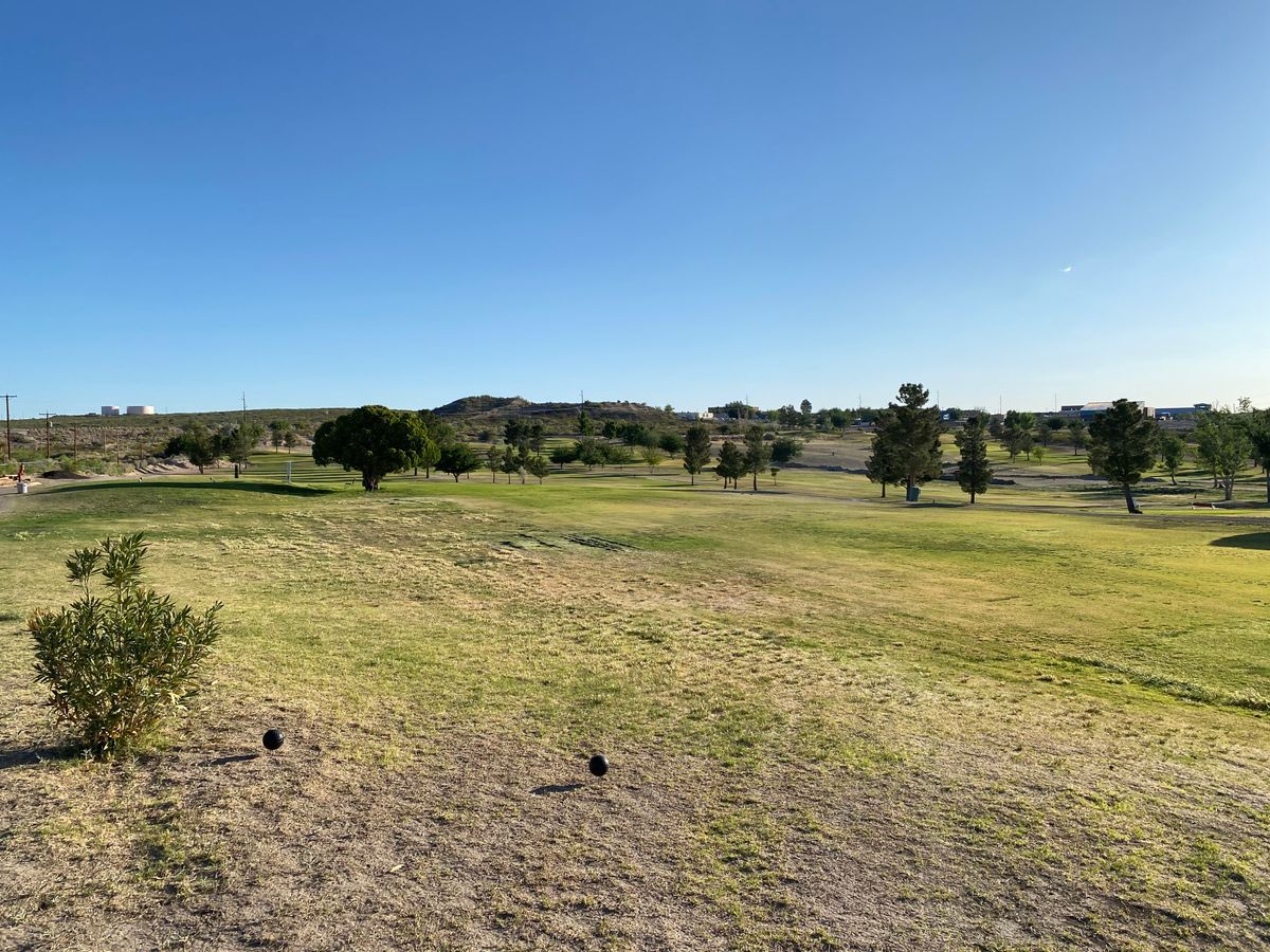 Hole 1 short (black) tee. Wide open, with a forgiving hill behind.