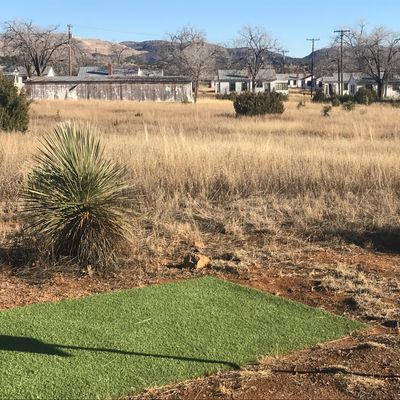 Turf tee pads behind old army barracks housing.