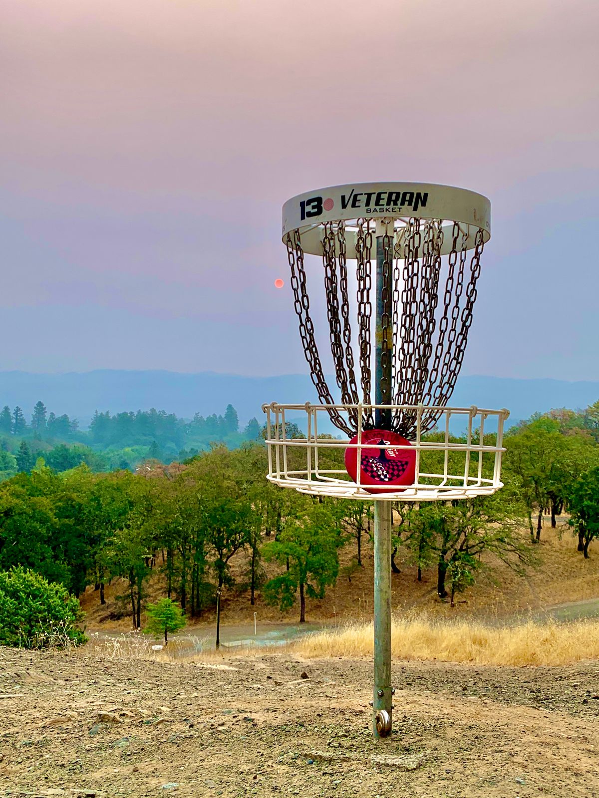 Hole 13 with smoke from fires and the sunrise in the background