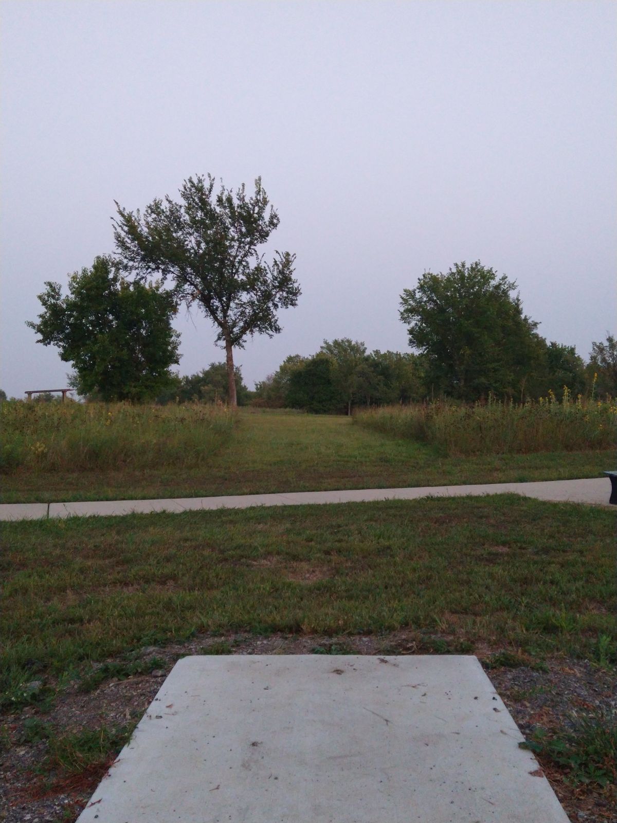 13th Tee Pad big dogleg to the right. There is a right hand line over the sidewalk to the south. Watch out for pedestrians.