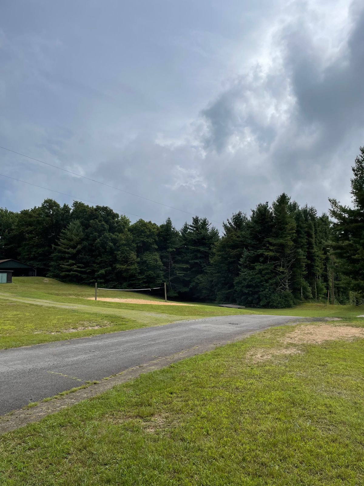 Hole 18 tee. Landing zone is down hill beyond the volleyball court.
