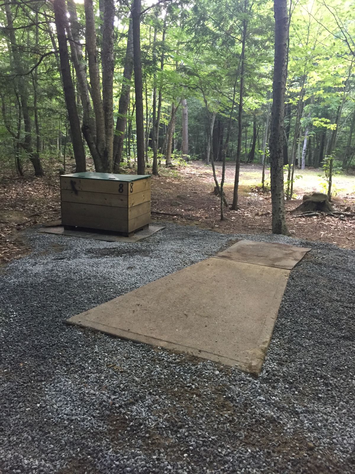 Concrete pads and trash/recycle boxes at each hole
