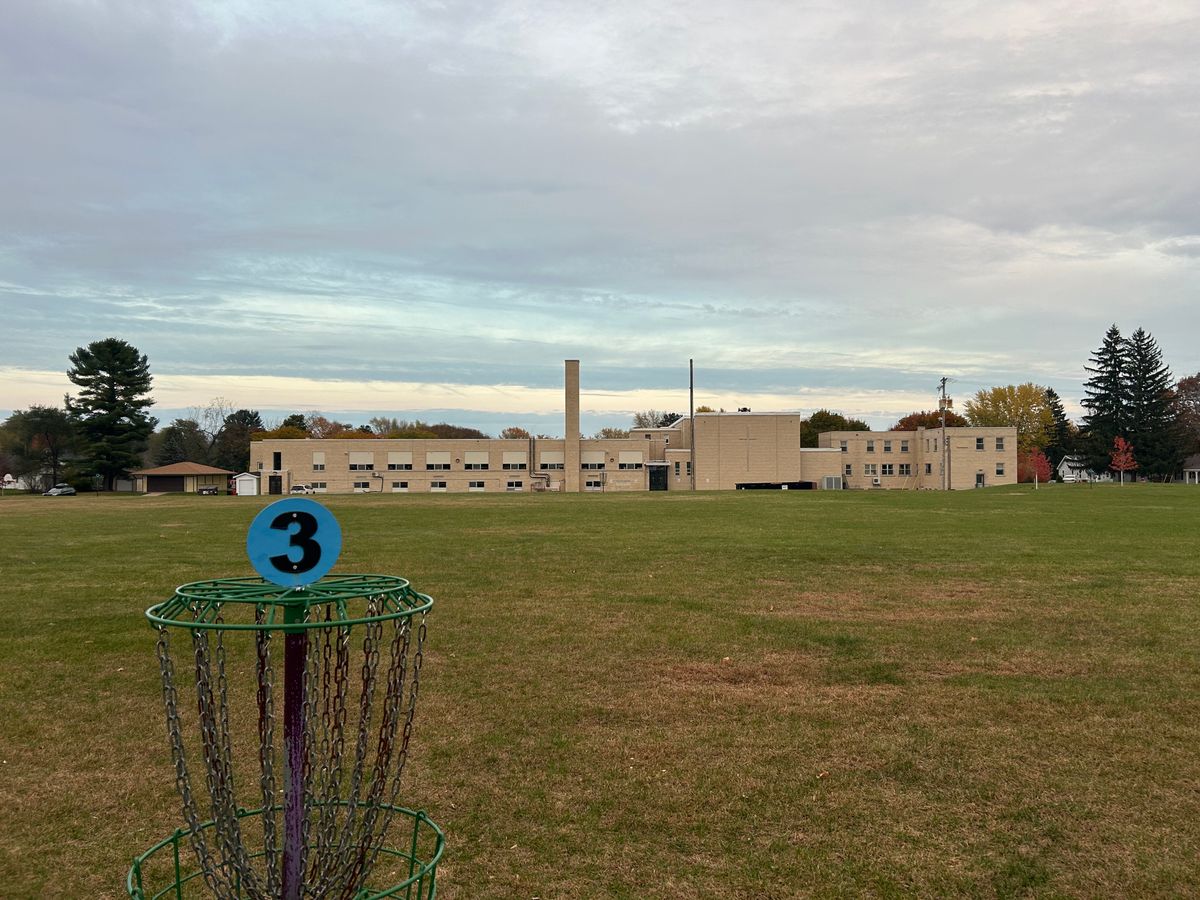 Hole 3 basket with school behind