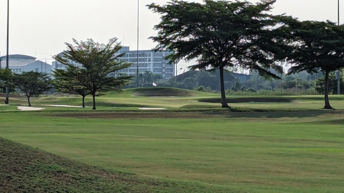 Tee of 18, zoomed. Basket on mound after ball golf flag and gets tighter after tee shot with sand and ball golf greens OB surrounding the basket with dropoff after basket.  Fantastic par 5 finishing hole!