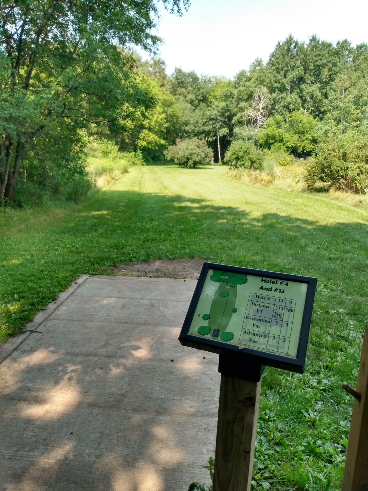 Hole 4 is long and back in the woods to the left a little. Hole 13 is short and straight ahead behind the bush.