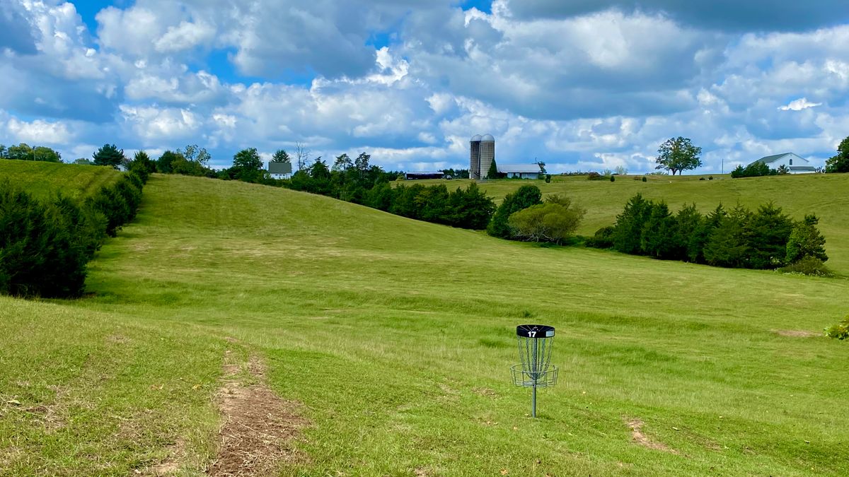 Hole 17’s basket, looking toward basket 18 (hidden behind hill left of silos)
