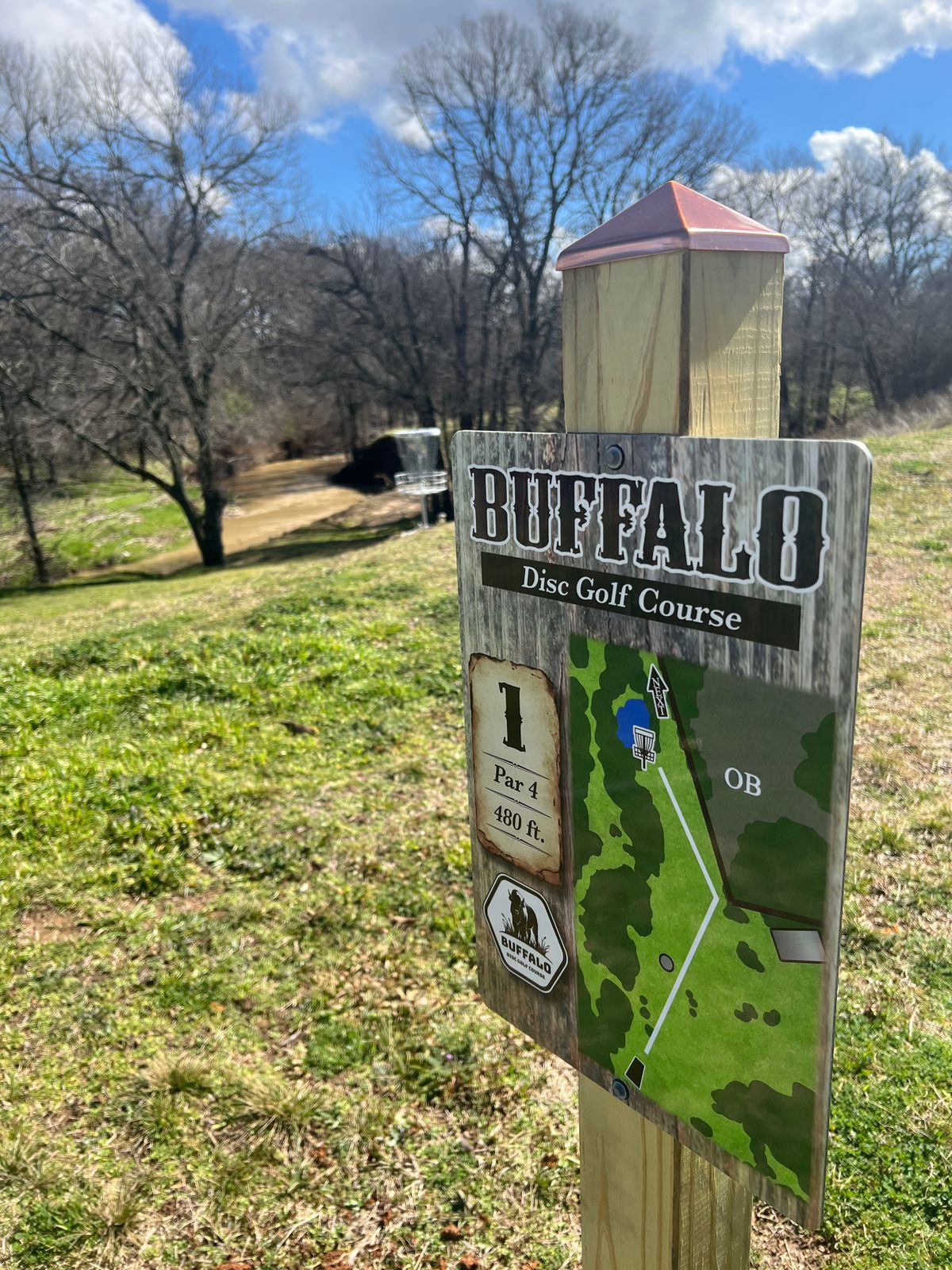 Hole 1 tee sign and a view of 18’s basket