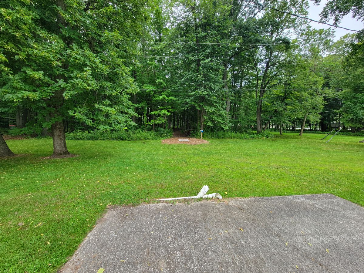 Hole 4s Long Teepad, with the short pad in view, facing towards the opening in the woods that is the fairway.