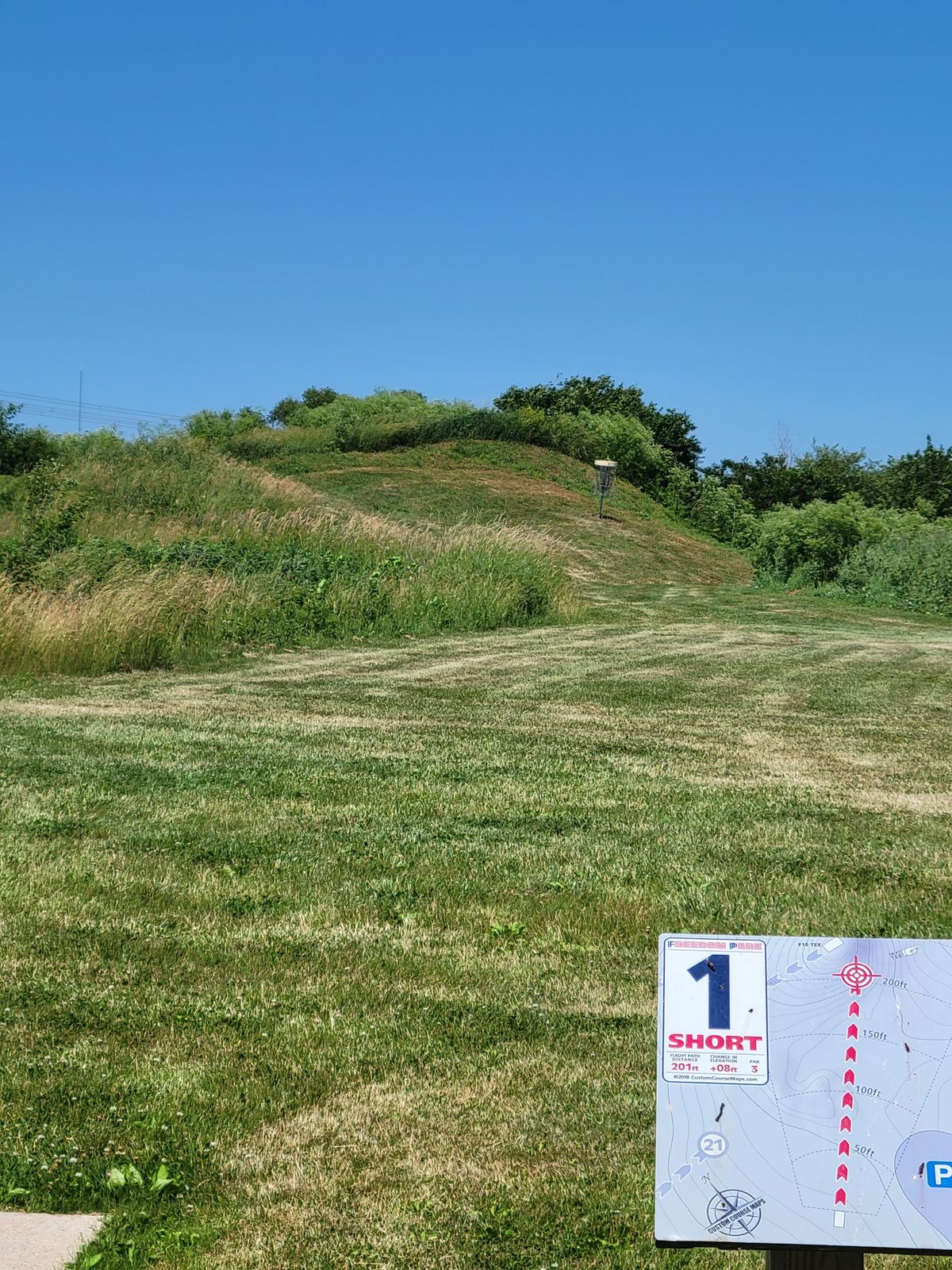 Hole 1 from the short tee, with knee-waist high rough.
