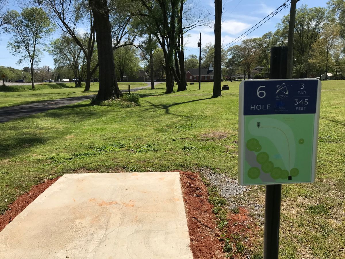 No. 6 tee box looking at basket beyond trees and left of power pole.