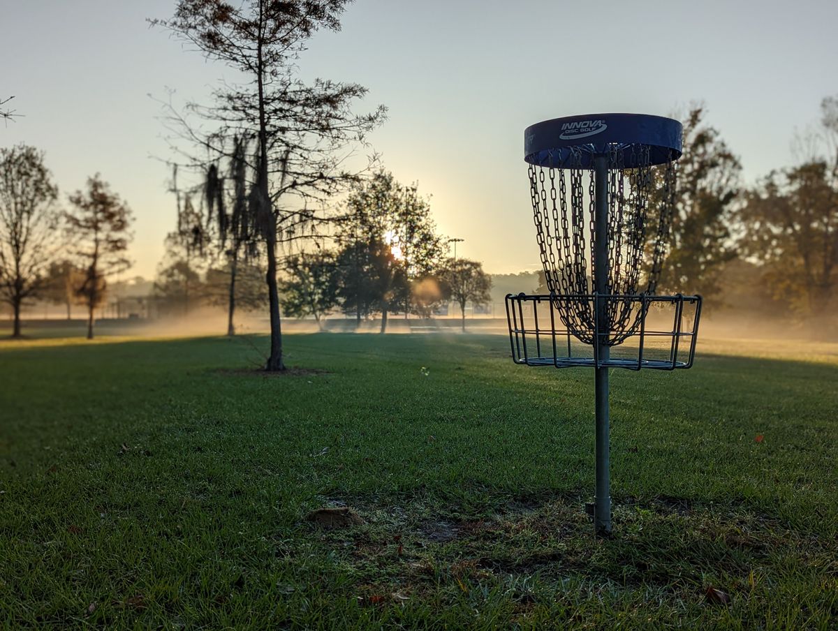 Hole 15 basket looking back down the fairway at sunrise.