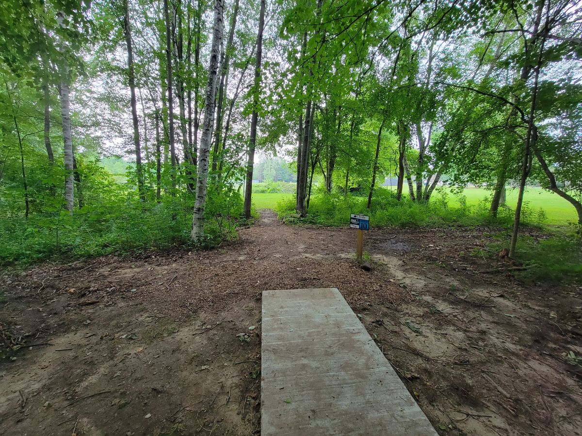 Hole 10s teepad facing the gap in the trees that marks the fairway to the basket.