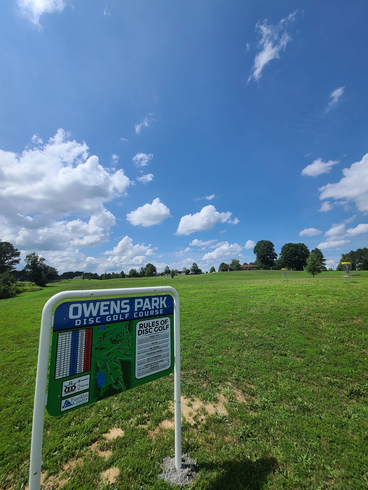 New course sign with practice baskets in the background