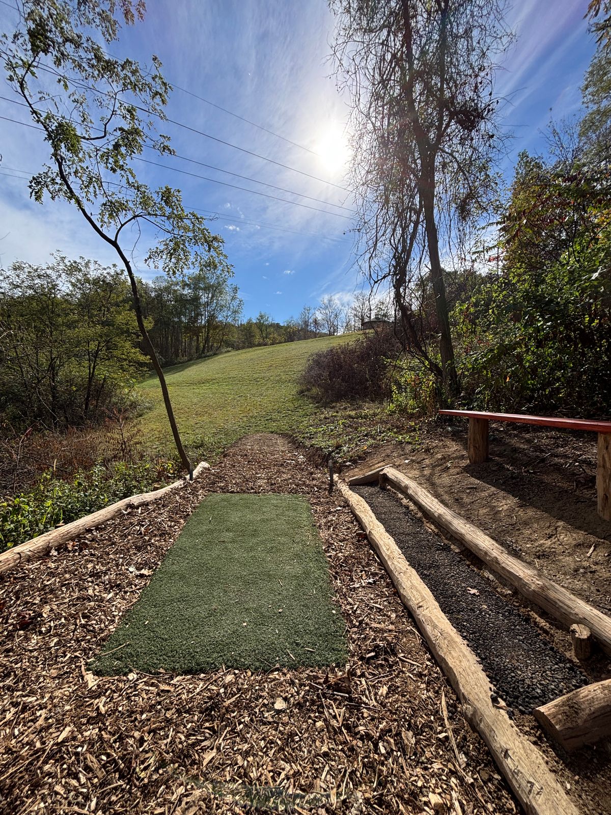 Hole 5 long tee and new cedar stained bench.