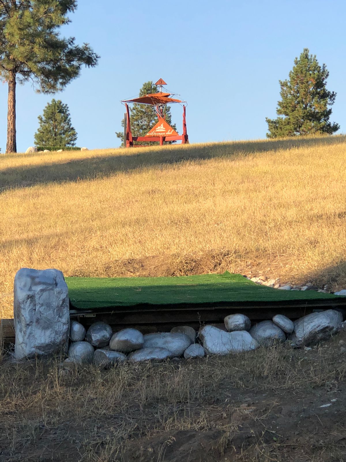 Hole 9 gold (short) tee pad - view of fairway to Black (long) tee pad and custom bench