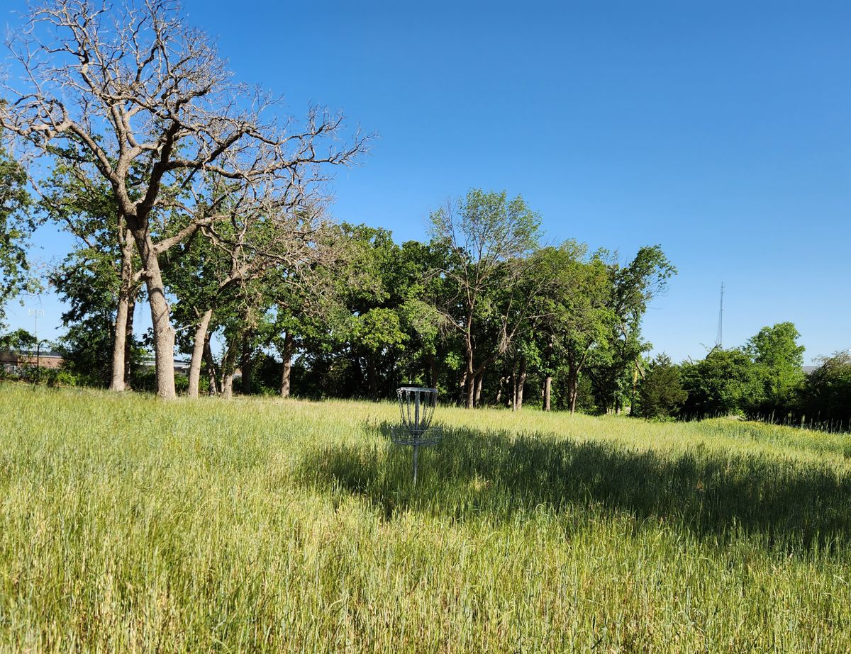 Basket in grassy field behind practice area